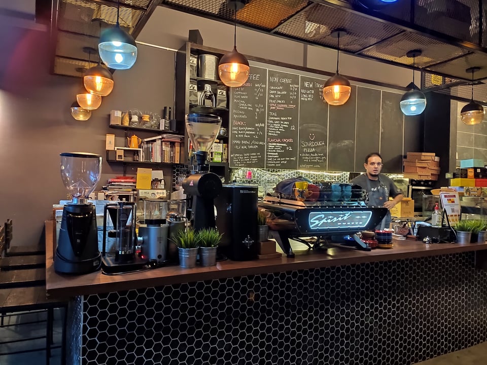 Latte art being poured at a specialty cafe counter in Kuala Lumpur