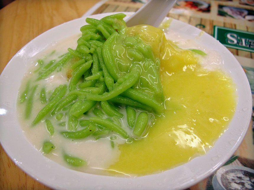 Bowl of cendol with green jelly, coconut milk and gula melaka at a Kuala Lumpur hawker stall