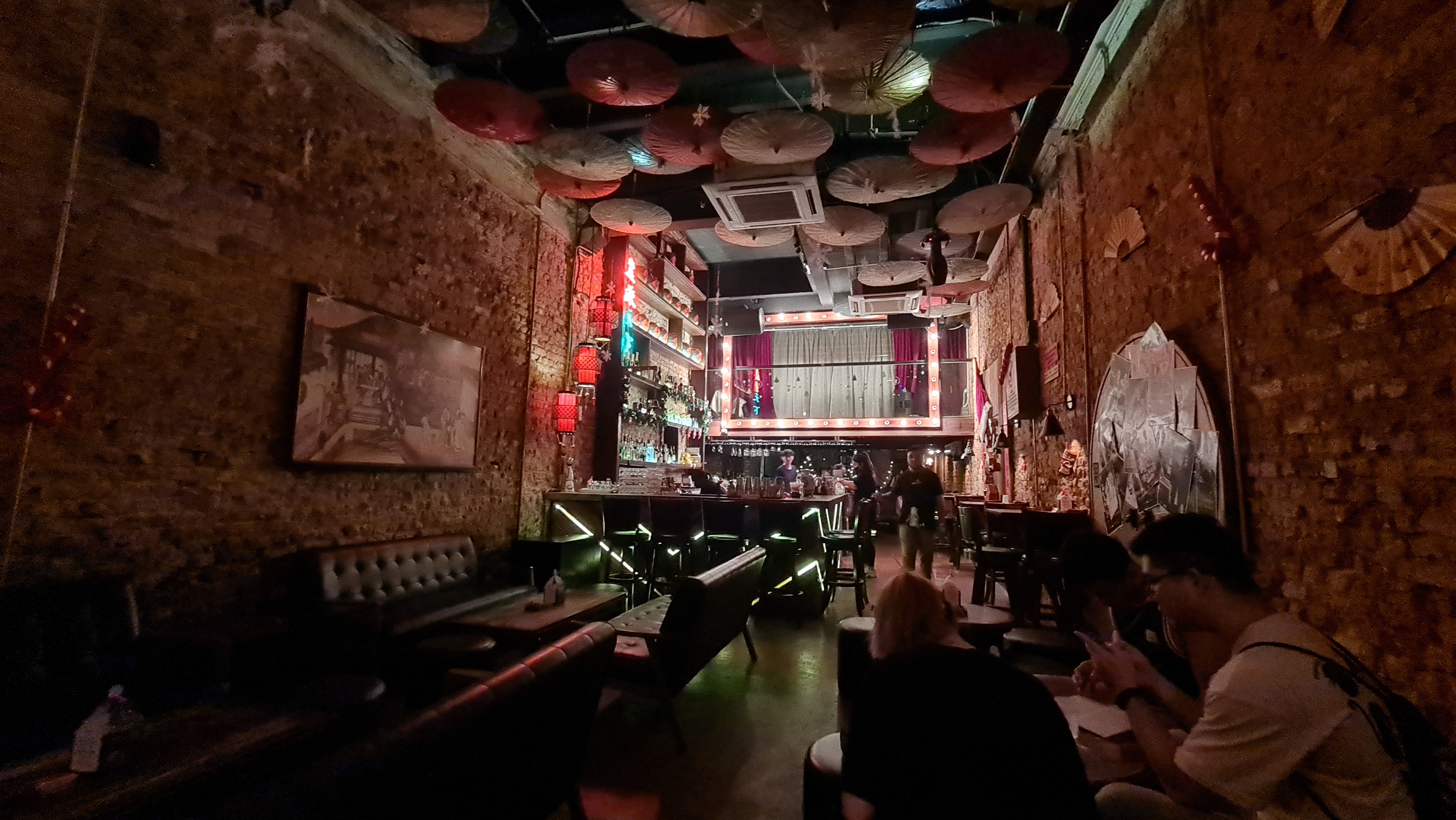 Dim interior of Magazine 63 speakeasy with exposed brick walls and Chinese porcelain jars