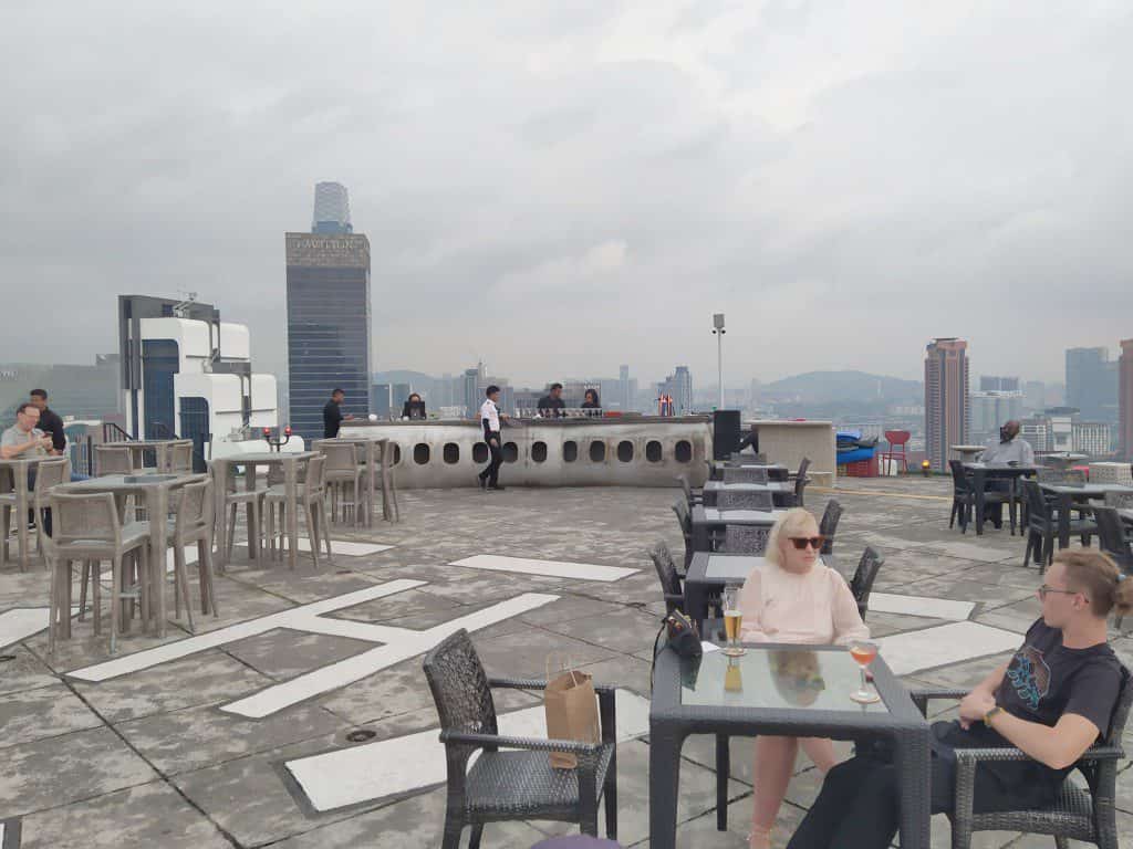 Heli Lounge Bar on the open helipad atop Menara KH with the KL skyline at sunset and no railings visible